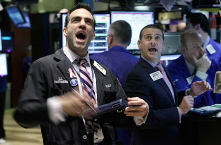 Traders react on the floor of the New York Stock Exchange. Companies are now sitting on cash, but they're going to need to spend it on investments and people for the economy to recover. (AP/Richard Drew)