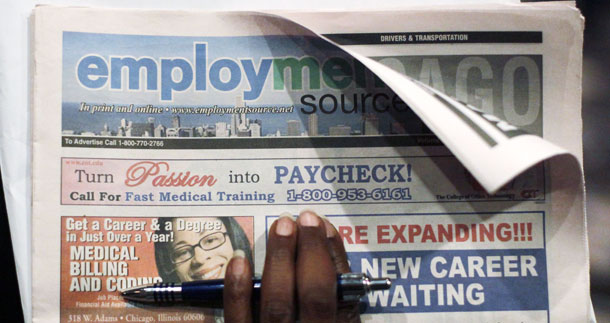 A woman holds onto an employment guide tabloid while attending a job fair in Chicago. (AP/Charles Rex Arbogast)