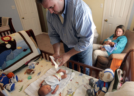 Tim and Stephanie Connor take time off work after the birth of their twins. Work-life conflict isn't just about families; it's about jobs and future economic growth, too. (AP/Donna McWillian)