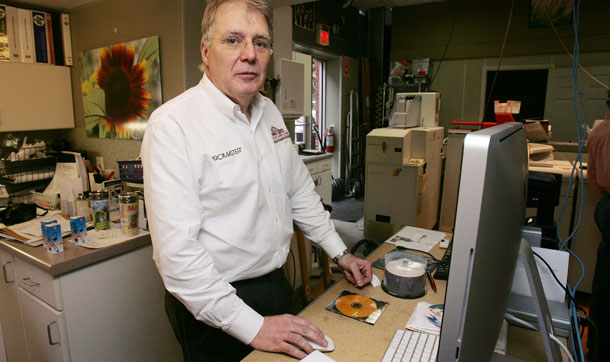 Michael St. Germain, president of Concord Camera, poses at his store in New Hampshire. St. Germain owns a small business and will likely benefit from the new health bill. (AP/Jim Cole)