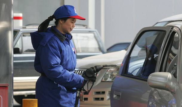 A Chinese gas station attendant gets ready to pump gasoline into a car in Beijing, China. Global oil demand—led by the United States and followed by China, Japan, and India—will dramatically increase over the next two decades. (AP/Greg Baker)