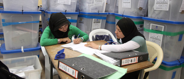 Electoral workers sit amid piles of ballot boxes at a counting center in Baghdad last month. (AP/Karim Kadim)