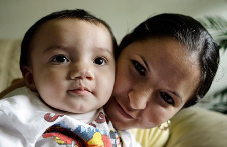 A mother holds her two-year-old son who was born with a cleft palate in Kettleman City, California. The city is surrounded by industrial and agricultural pollutants, and five in 20 children born from September 2007 to November 2008 had similar birth defects. (AP/Reed Saxon)