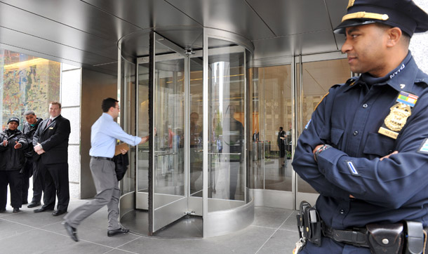 People enter the Goldman Sachs headquarters in the Lower Manhattan area of New York on Friday, April 16, 2010 as a security officer looks on. (AP/Diane Bondareff)