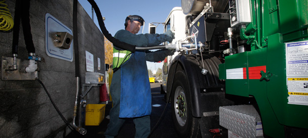 Mike Keele pumps liquefied natural gas onto a garbage truck at the Waste Management offices in Oakland, California, where almost 500 garbage and recycling trucks run on natural gas instead of diesel fuel. (AP/Marcio Jose Sanchez)