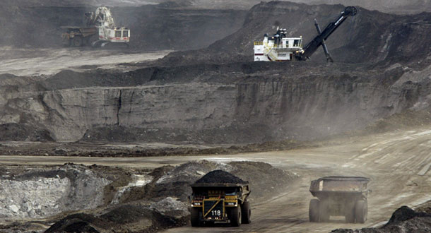 In this 2005 file photo, mining trucks carry loads of tar sands after being loaded by huge shovels at the Albian Sands project in Ft. McMurray, Alberta, Canada. How the tar sands debate plays out in Canada has significant implications for the United States. (AP/Jeff McIntosh)