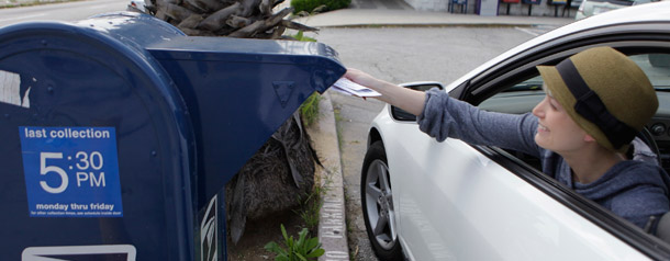 A woman uses a drive-in mail box to send off her incomes taxes in Los Angeles. (AP/Damian Dovarganes)