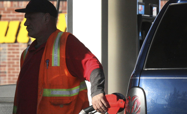 A man pumps gas into a vehicle in Portland, OR. Oil companies need to be held liable for the costs of their actions, and we need to cut the billions in unnecessary subsidies these profitable companies currently receive. (AP/Rick Bowmer)