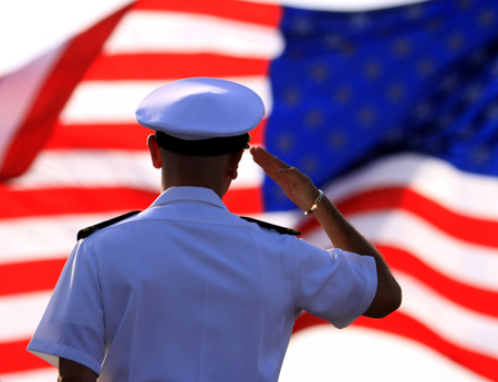 An unidentified sailor salutes a U.S. flag. The Senate Armed Services Committee voted 16 to 12 to include language  repealing the ban in the Defense Authorization bill, and the House voted  234 to 194 to do the same. (AP/Hasan Jamali)