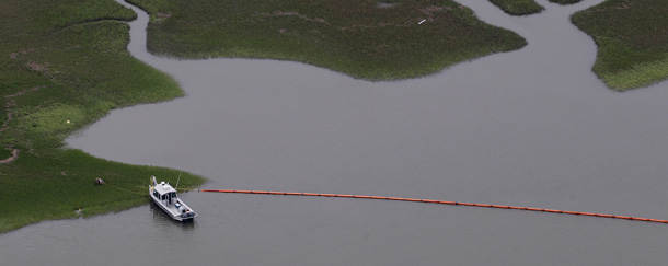 Workers place oil containment booms around in the central marshes in St. Bernard Parish, Louisiana. (AP/Eric Gay)