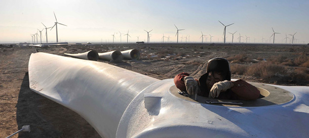 A worker installs a wind turbine in a wind farm. (AP)