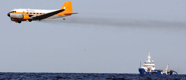 A dispersant plane passes over an oil skimmer as it cleans oil in the Gulf of Mexico near the coast of Louisiana. We do not actually know what chemicals are in many of these dispersants, or what their long-term health effects will be. (AP/Patrick Semansky)