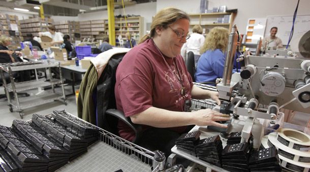 A worker puts labels on Playaway self-contained, battery-powered audio player books at the Findaway World headquarters in Solon, OH. Manufacturing added 44,000 jobs last month—more than double the jobs added in March. (AP/Amy Sancetta)