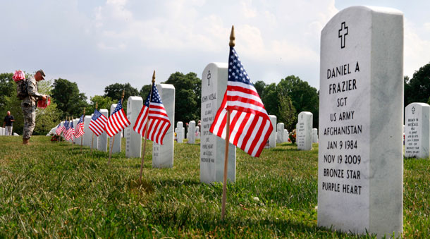 Army soldiers with the 3rd U.S. Infantry Regiment, known as "The Old Guard," place flags on each grave at Arlington National Cemetery in preparation for Memorial Day. (AP/Jacquelyn Martin)