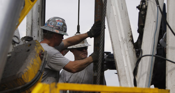 Crew members with Anadarko Petroleum Corporation work on a drilling platform on a farm near Mead, CO. If policymakers in Congress and the Obama administration manage to reduce our country’s dependence on oil, the cost of oil's risk premium to consumers could be spent on other things. (AP/Ed Andrieski)