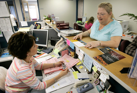 Two administrators talk in the continuing education office at Kirkwood Community College in Cedar Rapids, Iowa, which distributes WIA funds. (AP/Charlie Neibergall)