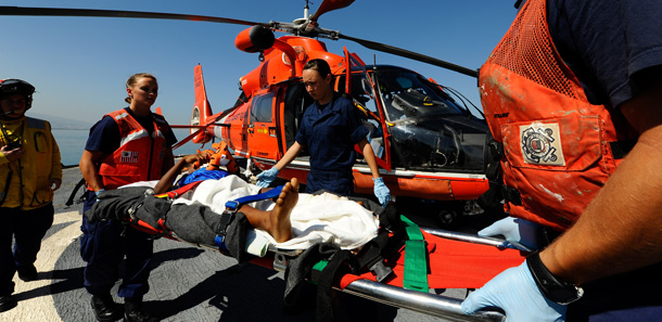 U.S. Coast Guard Cutter Mohawk crew members help carry a young Haitian girl on a stretcher to a Dolphin rescue helicopter in Port-au-Prince, Haiti. (AP/USCG)