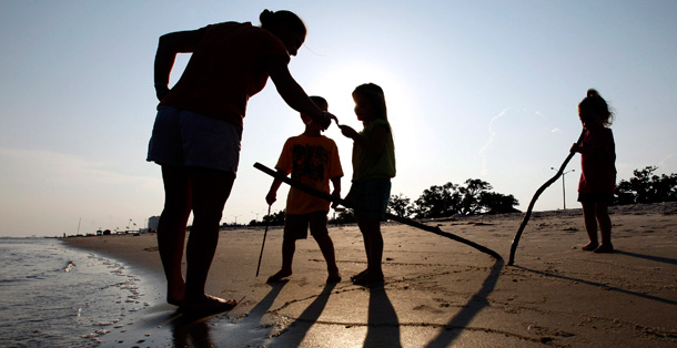 A group of children in Mississippi look at the beach near their homes to see the environmental degradation beginning to occur there due to the BP oil disaster. (AP/Patrick Semansky)