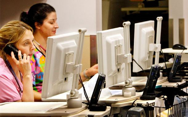 Two nurses check terminals in an array of computers on wheels, called COWS, at Children's Hospital in Pittsburgh. (AP/Keith Srakocic)