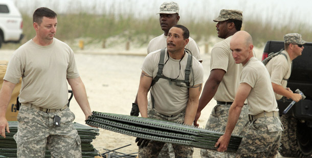 Members of the U.S. Army National Guard B Company 711 put Hesco containers designed to absorb oil along the beaches of Dauphin Island, AL, on May 2, 2010. The Obama administration has authorized 17,500 National Guard troops from the Gulf Coast states to respond to the disaster. (AP/Michelle Rolls-Thomas)