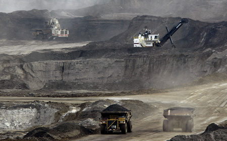 Mining trucks carry loads of oil laden sand after being loaded by huge shovels at the Albian Sands oils sands project in Ft. McMurray, Alberta, Canada. (Ap/Jeff McIntosh)