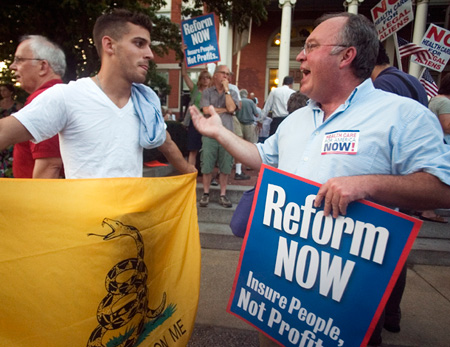 A student who is against the government forcing people to spend money on health care discusses health care reform with a man in favor of reform outside a town hall meeting in Warwick, Rhode Island. (AP/Stew Milne)