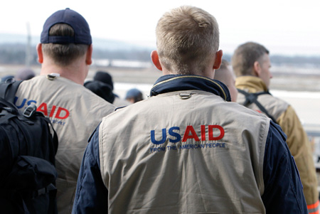 United States Agency for International Development search and rescue officials walk out of a cargo terminal to board a plane to Haiti. (AP/Alex Brandon)