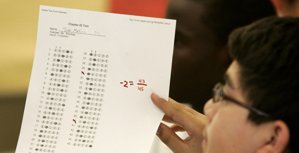 KIPP charter school student Jorge Martina holds up a practice test paper during class in Houston. School models like KIPP, Yes Prep, and Achievement First have achieved unprecedented outcomes for students in poverty and have even outachieved schools with higher-income students. (AP/Pat Sullivan)