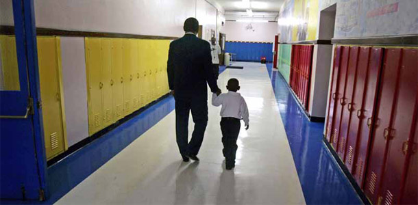 A man holds a child's hand in an elementary school hallway in Detroit. Real quality control for teacher preparation programs would hold programs accountable for how their graduates perform in the classroom. (AP/Carlos Osorio)