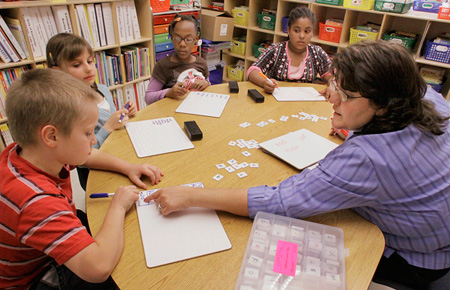 A Title I resource reading and math teacher works with her third grade students at Ridgely Elementary School in Springfield, Illinois. (AP/Seth Perlman)