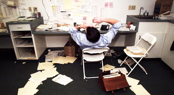 A typical campaign worker in Iowa sits at a desk surrounded by papers. Cutting back on paper use and recycling are some good ways to make your campaign a greener one. (AP/Stephen Savoia)