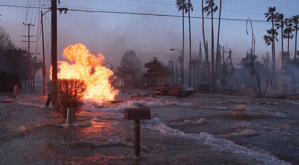 A gas main burns even as water from broken water mains flood a portion of Balboa Blvd. in Los Angeles Monday morning, Jan. 17, 1994. (AP/Lenny Ignelzi)