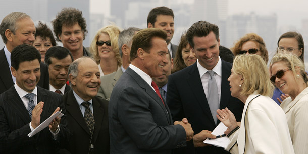 Gobernador de California Arnold Schwarzenegger, centro, se da la mano con el Alcalde de San Francisco Gavin Newsom después de firmar el proyecto de ley AB 32, la Ley de Soluciones para el Calentamiento Global en California del 2006. La AB 32 ahora está siendo atacada por la Proposición 23. (AP/Ben Margot)