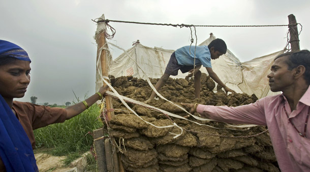 Indian men sell dung cakes to residents in New Delhi that are commonly used as cooking fuel in rural India. Cookstoves that use dung and other biomass as fuel give off toxic smoke and are believed to contribute to climate change. (AP/Gurinder Osan)