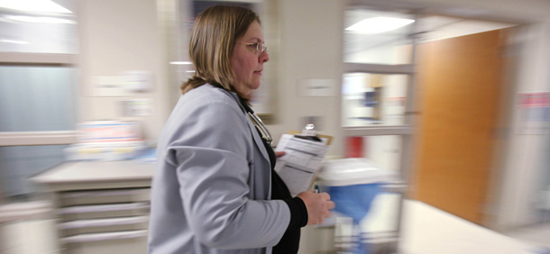 A doctor rushes through the emergency room visiting her patients. States have an urgent need to modernize the medical care system to improve the quality of care while simultaneously lowering its cost. (AP/Kiichiro Sato)