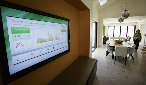 Anne Rashford, director of temporary exhibits at Chicago's Museum of Science and Industry, is seen inside the SmartHome exhibit where a monitor displays the energy and water usage of the home. More gadgets and gizmos are entering the market that let consumers track their power use.
  (AP/M. Spencer Green)