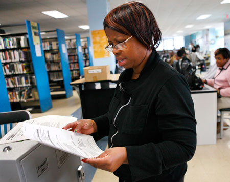 Marilyn Brundage, who has been looking for fulltime work over the last year while temping in the meantime, looks over print outs of job openings. (AP/Jacquelyn Martin)