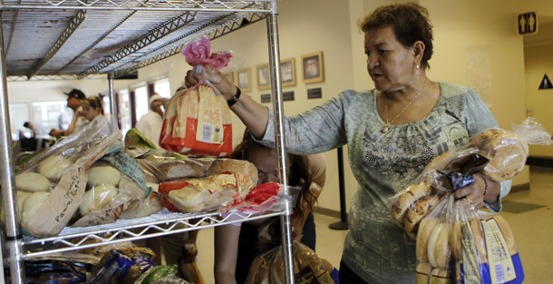 A woman stocks up on bread at Sacred Heart Community Center in San Jose, CA, on September 16, 2010. The percentage of people living in poverty jumped for the third year in a row, reaching 14.3 percent in 2009. But all Washington wants to talk about is tax cuts for the rich. (AP/Marcio Jose Sanchez)