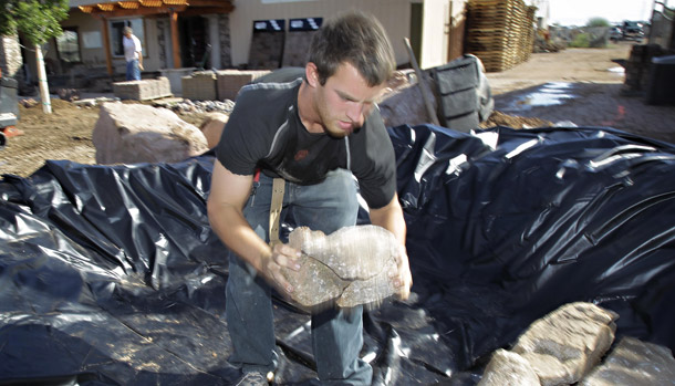 KW Hardscape employee Eric Hengehold stacks stones in an accent pond on October 21, 2010 in Chandler, AZ. Arizona's unemployment rate stands at 9.7 percent for the second consecutive month. (AP/Matt York)