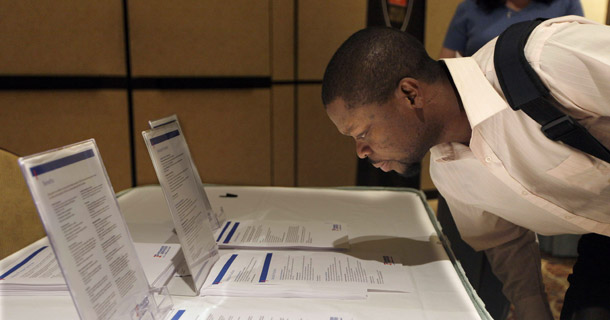 Mark Cozart of Las Vegas reads listings for job opportunities at a job fair on October 5, 2010, in Las Vegas. The private sector added jobs last month, but not enough to bring down the near-record-high unemployment rate of 9.6 percent. (AP/Julie Jacobson)