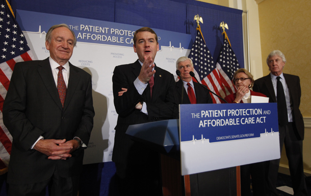 Sen. Michael Bennet (D-CO), second from left, gestures during a news conference on Capitol Hill in Washington. Affordable Care Act provisions specifically affecting Medicare should significantly improve Medicare’s medium-term fiscal position. (AP/Gerald Herbert)