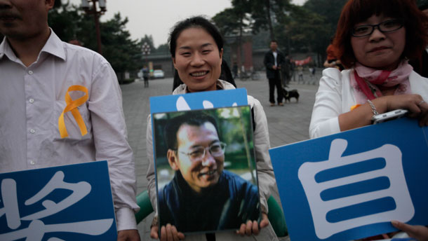 Supporters of Liu Xiaobo holding his picture gather outside a park in Beijing. Imprisoned Chinese dissident Liu won the 2010 Nobel Peace Prize on Friday for using nonviolence to demand fundamental human rights in his homeland. (AP/Vincent Yu)