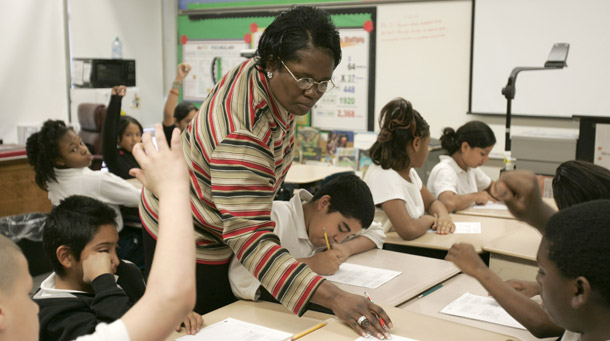 A teacher at Kennedy Elementary School in Houston, TX, works with her fifth-grade students on math problems. (AP/Pat Sullivan)