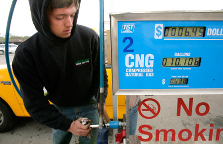 A man in Murray, Utah, puts the pump handle back after filling his truck up at a compressed natural gas station. (AP/Douglas C. Pizac)