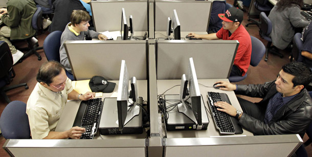 Unemployed workers fill out online resumes at the Maricopa County Workforce Connections job fair on November 23, 2010, in Phoenix, AZ. Economic growth is subdued, and job creation stays sluggish. (AP/Matt York)