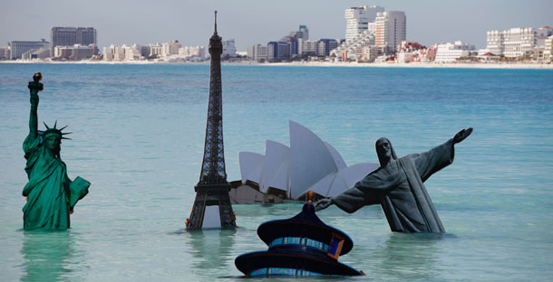 Environmental activists demonstrate by holding images of world landmarks in the water during the United Nations Climate Change Conference in Cancun, Mexico. (AP/Eduardo Verdugo)