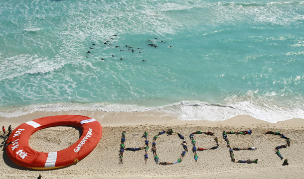 Greenpeace activists form the word "hope" as a question with their bodies, next to a giant lifesaver, during a demonstration near the site of the U.N. Climate Change Conference in Cancun, Mexico, Friday, December 10, 2010. (AP/Israel Leal)