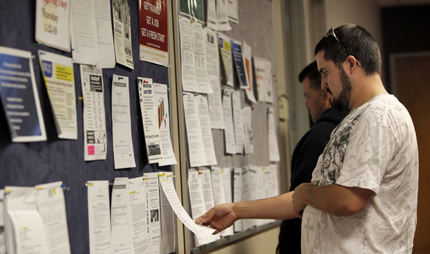 Jay Bashant, of Buckyeye, AZ, looks over job ads at the Maricopa County Workforce Connections job fair in Phoenix on November 23, 2010. The unemployment rate remains high while families experience massive financial distress as foreclosures and credit defaults hover near record highs. (AP/Matt York)