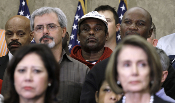 Unemployed workers stand behind Labor Secretary Hilda Solis, left, and House Speaker Nancy Pelosi during a news conference on Capitol Hill in Washington, Wednesday, December 1, 2010. (AP/Harry Hamburg)