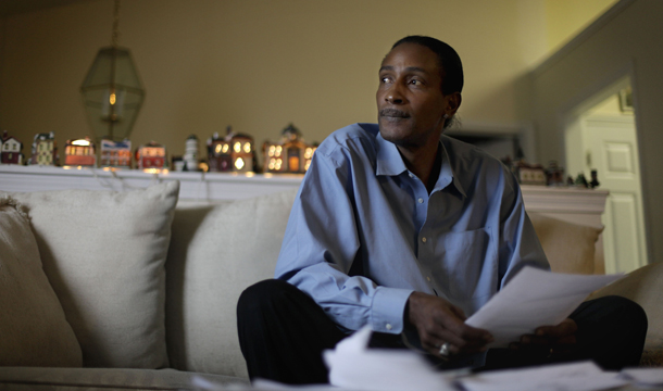 Wayne Pittman, 46, sits in his Lawrenceville, GA, home looking over unemployment papers. The jobless rate in November for black Americans remained at a stagnant 16 percent over the previous month. (AP/David Goldman)